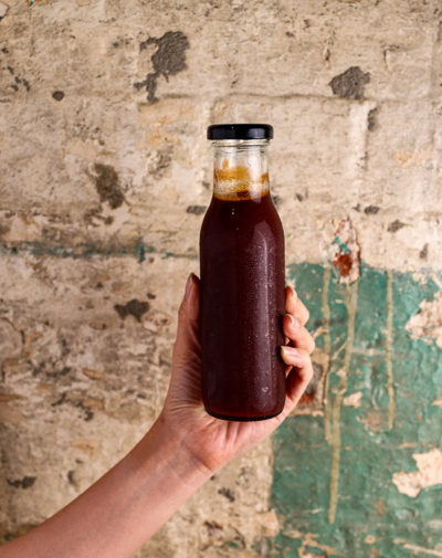 Frankie's Smokehouse BBQ Sauce in glass bottle being help